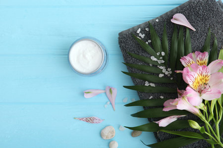 Care cream and flowers on a colored background top view. Skin care cosmetics.の写真素材