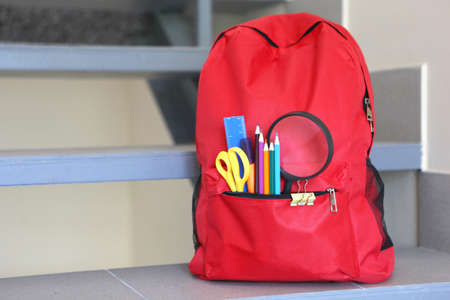 School backpack and stationery in a bright room.