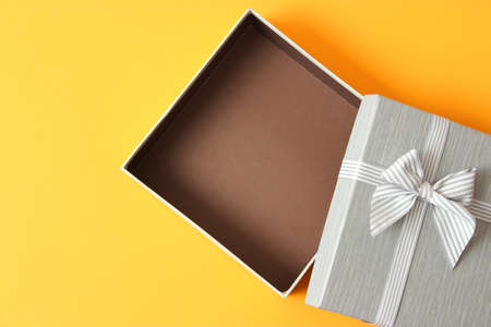 open gift box and confetti on a colored background top view.の写真素材