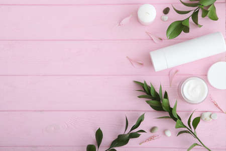 Care cream and flowers on a colored background top view. Skin care cosmetics.の写真素材