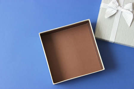 open gift box and confetti on a colored background top view.