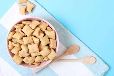 dry breakfast in a plate on a colored background top view. cereal