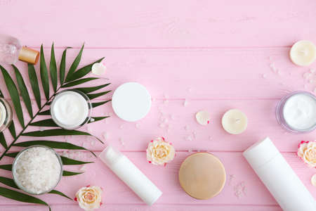 Care cream and flowers on a colored background top view. Skin care cosmetics.の写真素材