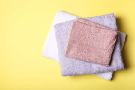 Fresh towels on a colored background with place for text top view.の写真素材