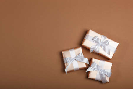 Gifts in gold packaging on a colored background with place for text.の写真素材