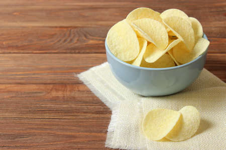 Potato chips in a plate on a colored background top view.の写真素材