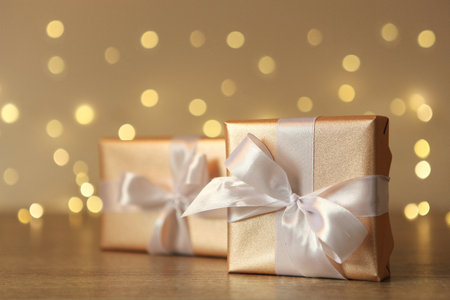 Gifts in gold packaging on a colored background with place for text.の写真素材