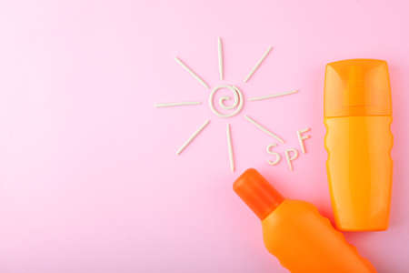 Sunscreens on a colored background top view.