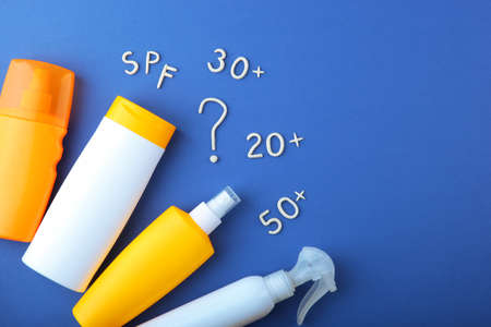 Sunscreens on a colored background top view.