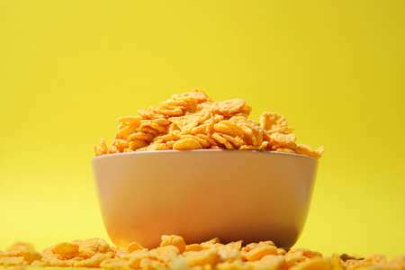 Delicious cornflakes in a plate against colored background.の写真素材