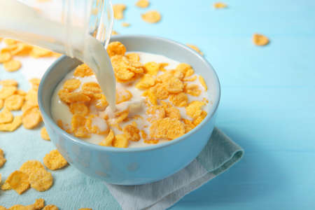 Crispy cornflakes with milk for breakfast on a colored background close-up.の写真素材