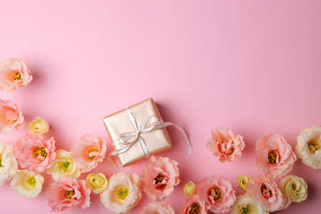 flower arrangement and gift on colored background top view with place for textの写真素材