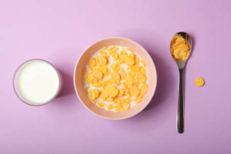 Crispy cornflakes with milk for breakfast on a colored background close-up.の写真素材