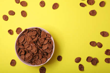 chocolate cornflakes for breakfast on colored background close up