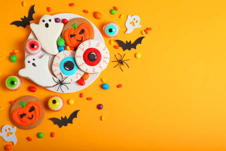 Halloween sweets on colored background close up top view with place for textの写真素材