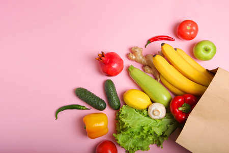 Products in a paper bag on a colored background with place for text top view.の写真素材