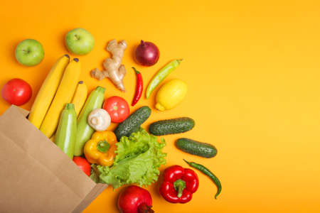 Products in a paper bag on a colored background with place for text top view.の写真素材