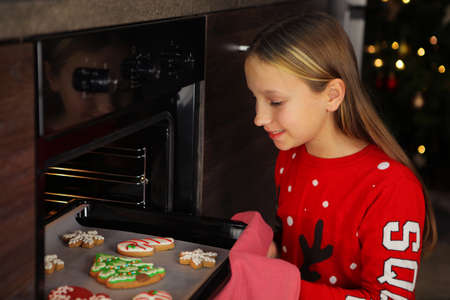 Teenage girl baking christmas gingerbread cookies at homeの写真素材