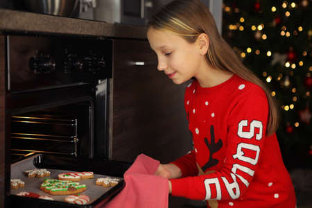 Teenage girl baking christmas gingerbread cookies at homeの写真素材