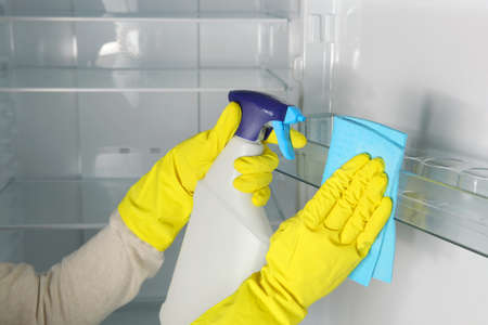 A woman washes the refrigerator with disinfectants close-up.の写真素材