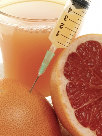 Injecting a Pink Grapefruitの写真素材