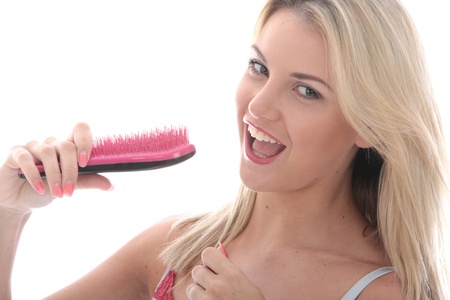 Model Released. Attractive Young Woman Singing into a Hairbrushの写真素材