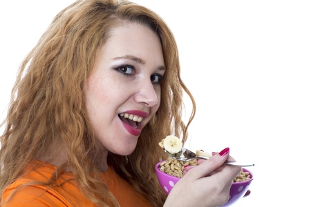 Model Released. Happy Young WEoman Eating Breakfast Cereal