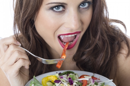 Model Released. Attractive Young Woman Eating Stir Fried Vegetablesの写真素材