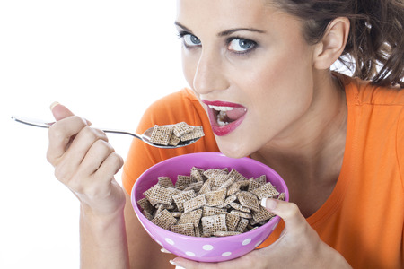 Model Released. Attractive Young Woman Eating Breakfast Cereal