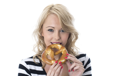 Model Released. Attractive Young Woman Eating a Pretzelの写真素材