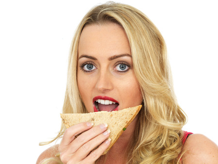 Attractive Young Woman Eating a Sandwichの写真素材