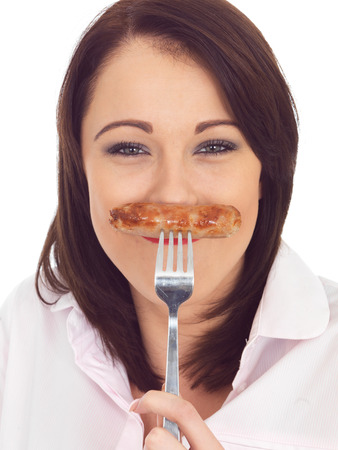 Attractive Young Woman Holding a Pork Sausage on a Forkの写真素材