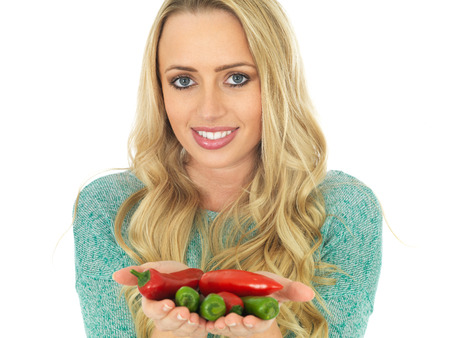 Attractive Young woman Holding Spicy Red and Green Chilliesの写真素材