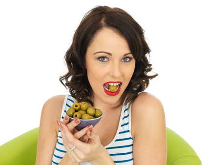 Young Healthy Woman Eating Green Olivesの写真素材