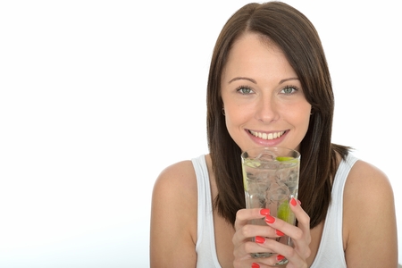 Healthy Young Woman Holding a Glass of Iced Water with Limeの写真素材