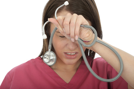 Stressed And Upset Young Female Doctor Resting Hwer Head on Her Hands Against A White Backgroundの写真素材