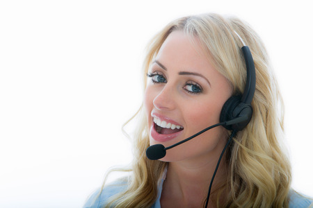 Attractive Young Business Woman Using a Telephone Headset Calling Clients Against A White Background Attractive Young Business Woman Using a Telephone Headset Calling Clients Against A White Background