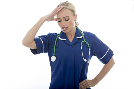 Attractive Young Woman Posing As A Doctor or Nurse In Theatre Scrubs With A Stethoscope Isolated against a Plain White Backgroundの写真素材