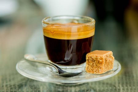 Cup of Strong Single Shot Expresso Coffe in a Glass Cup With Fudge On A Tableの写真素材