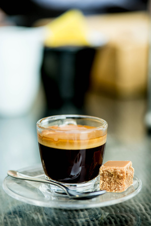 Cup of Strong Single Shot Expresso Coffe in a Glass Cup With Fudge On A Tableの写真素材