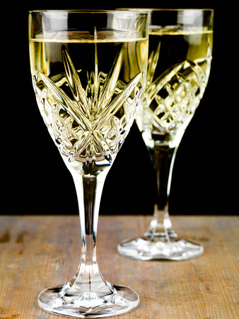 Chilled White Wine in a Cut Crystal Glass Against a Black Backgorund Chilled White Wine in a Cut Crystal Glass Against a Black Backgorund