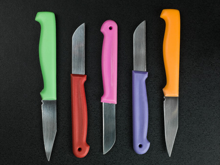 Set of Colorful Kitchen Knives Against a Black Backgroundの写真素材