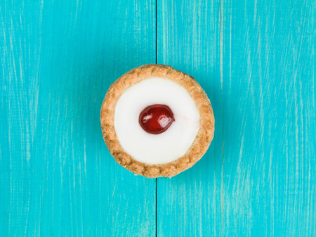 Single Bakewell Tart Dessert on a Blue Backgroundの写真素材