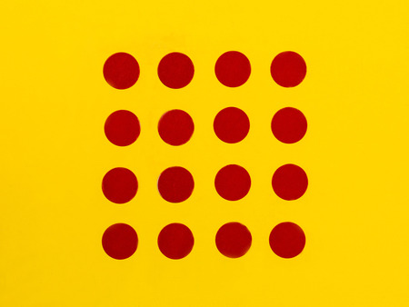 Red Dots on a Bright Yellow Background With Copy Spaceの写真素材