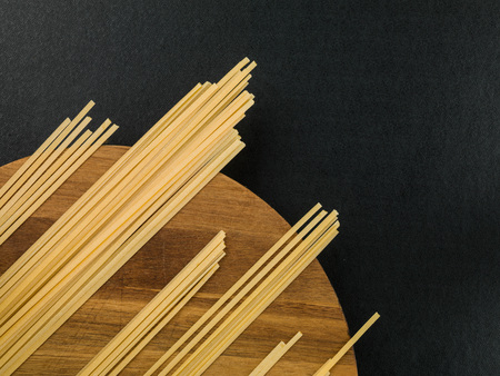 Dried Italian Style Linguini Pasta on a Kitchen Chopping Boardの写真素材