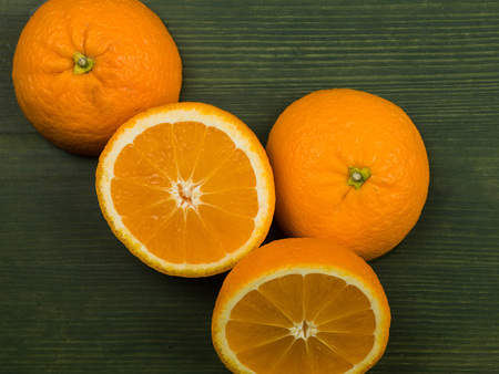 Fresh Ripe Healthy Juicy Oranges on a Green Background