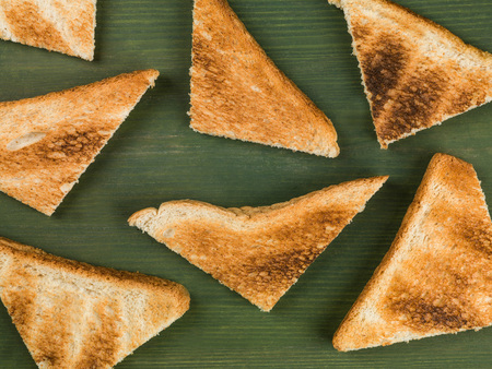 Toast Triangles in a Random Pattern Against a Green Background