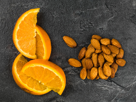 Fresh Orange With Almond Nuts Against a Black Backgroundの写真素材