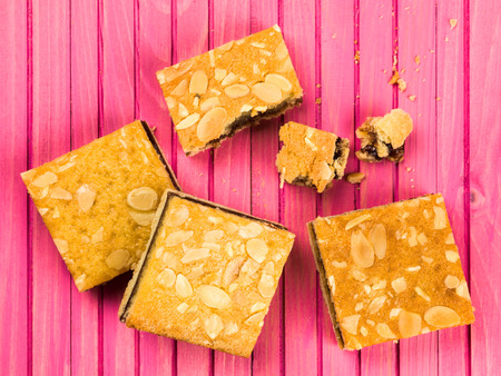 Cherry Bakewell Cake Slices or Squares Against a Pink Backgroundの写真素材