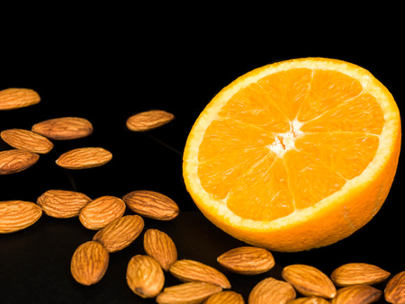 Fresh Orange With Roast Almond Nuts Against a Black Backgroundの写真素材